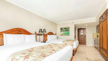A hotel room with two beds, a wooden headboard, a nightstand, a lamp, and a painting of a beach scene.