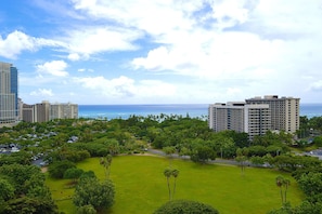 A hotel with multiple high-rise buildings, a well-maintained lawn, and a view of the ocean. - Luana Waikiki Hotel & Suites (Honolulu)