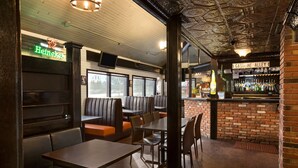 A restaurant interior with booths, tables, and a bar area. - South Hill Lodge (Prince Albert)