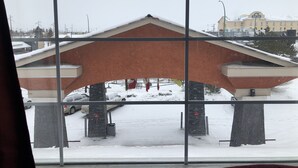 A Day Inn building with a snow-covered roof and a parking area in front. - South Hill Lodge (Prince Albert)