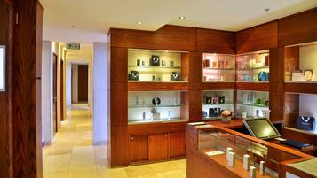 A hotel lobby with wooden paneling, glass display cases, and a reception desk.