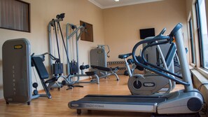 A gym with various exercise equipment including treadmills, ellipticals, and weight machines. - Premier Hotel The Richards (Richards Bay)