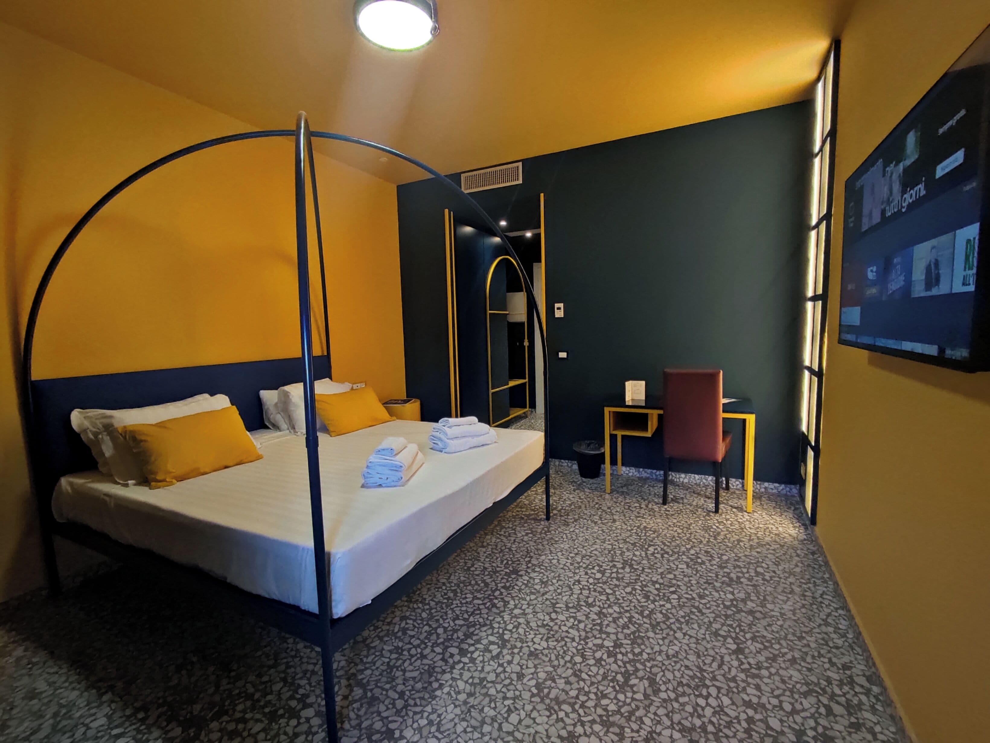 Een hotelkamer met een hemelbed, een bureau en een stoel.