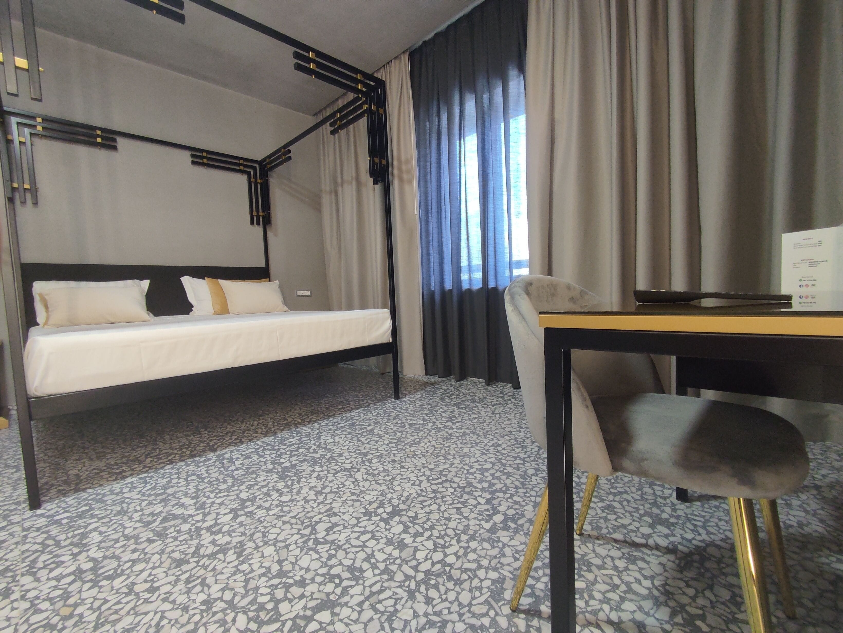 A hotel room with a bed, a desk, and a chair.