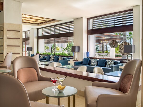 A modern lounge area with sofas, armchairs, and a bar. - H10 Estepona Palace (Estepona)