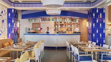 Un restaurante con área de bar, techo de madera y paredes con diseño azulado.