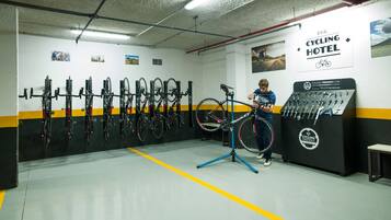 Un hotel para ciclistas con un soporte para bicicletas de pared, una bicicleta estática y un taller de reparación de bicicletas.
