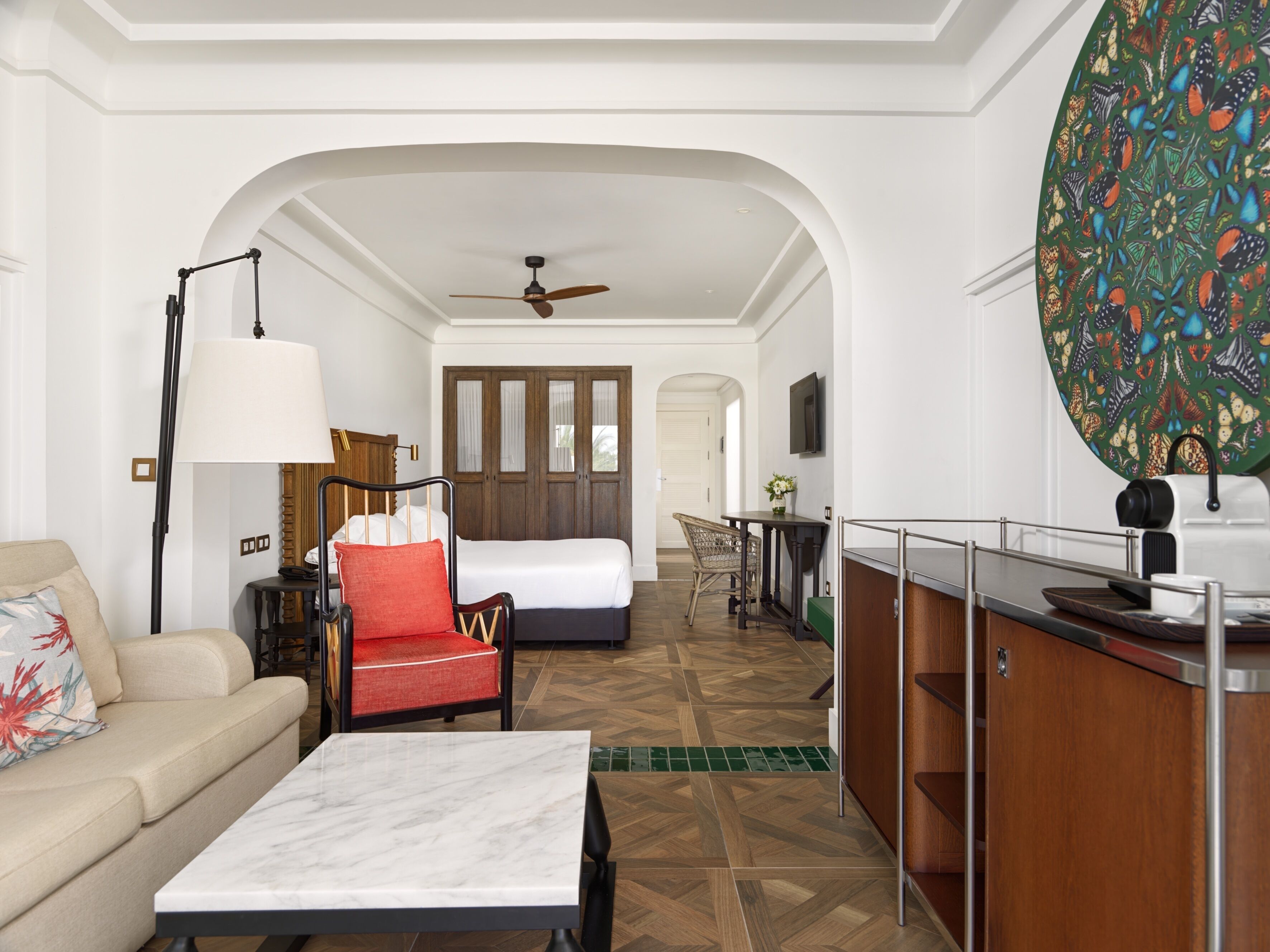 Une chambre d’hôtel comprenant un lit, un canapé, une table à manger, une chaise, un bureau et un coin cuisine.