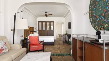 Une chambre d’hôtel comprenant un lit, un canapé, une table à manger, une chaise, un bureau et un coin cuisine.