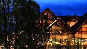 A modern hotel with a distinctive architectural design featuring multiple triangular roofs and large windows.