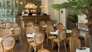 A restaurant interior with wicker chairs, round tables, a bar area, and decorative ceiling lights. - Hôtel La Villa Nice Victor Hugo (Nice)