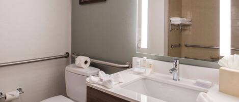 A modern bathroom with a toilet, sink, and shower.