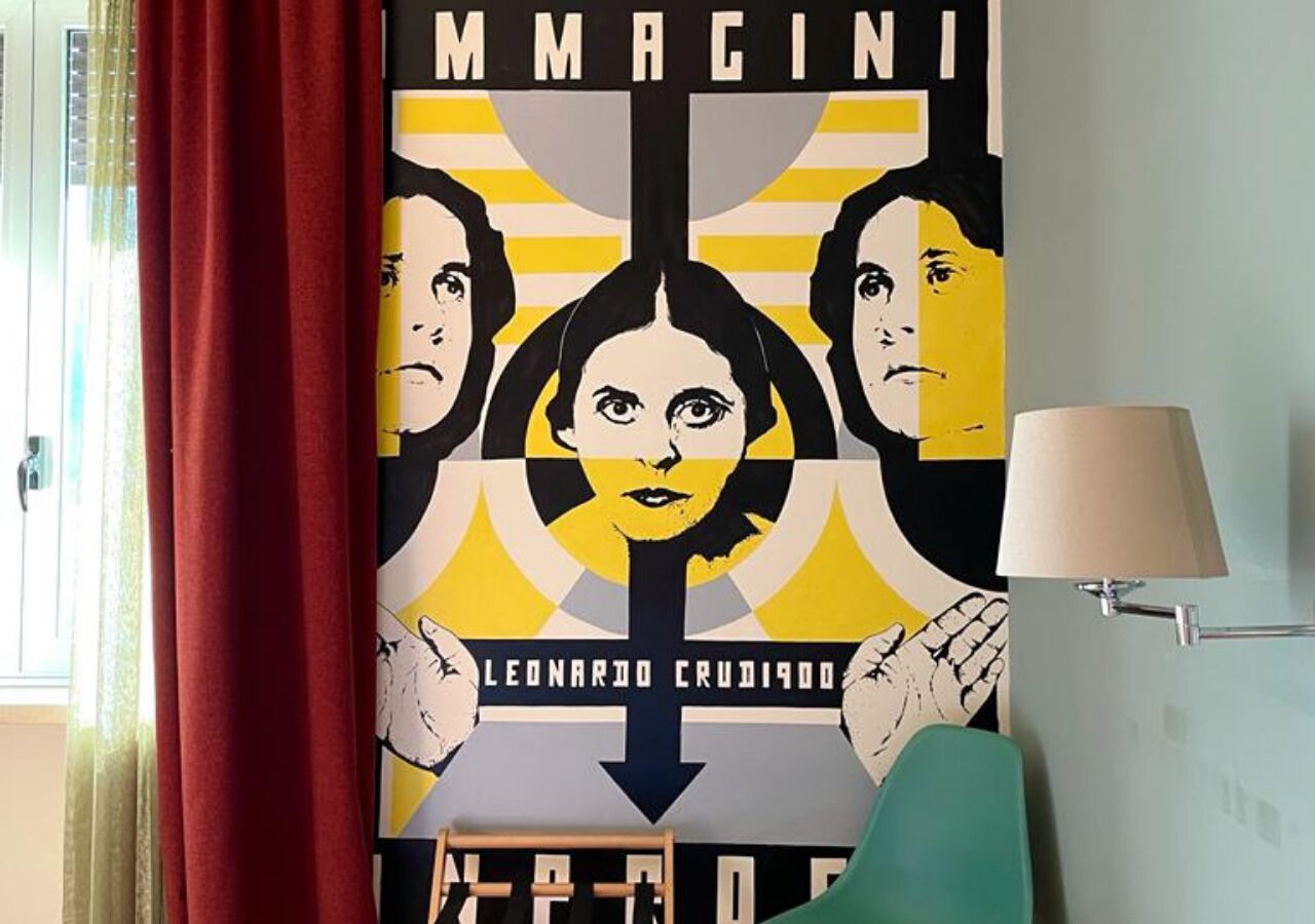 Une affiche sur laquelle on peut lire les mots « MMACINI » et « LEONARDO CRUDIAGO », et qui est accrochée à un mur.