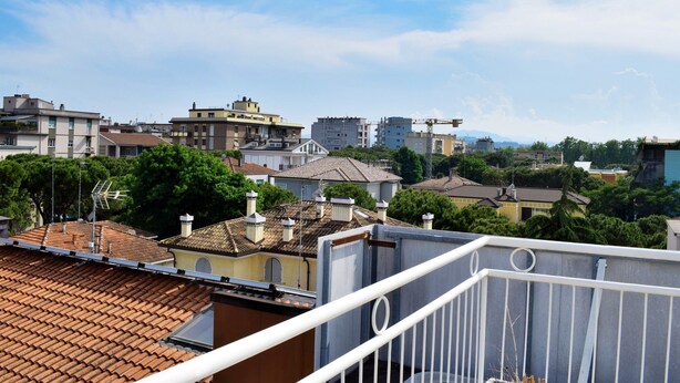 A residential area with terracotta-tiled roofs, a mix of modern and traditional buildings, and a clear sky. - Hotel Bamby (Rimini)