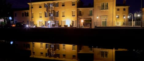 Un edificio con varias ventanas y balcones que se reflejan en el agua.