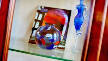 Una teca in vetro con un vaso di vetro colorato e una scultura in vetro blu.