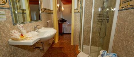 Un baño con dos lavamanos, una ducha y un inodoro.