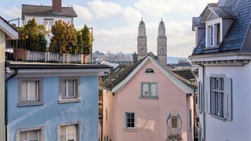 Una hilera de edificios de colores pastel con vistas a dos torres históricas al fondo.