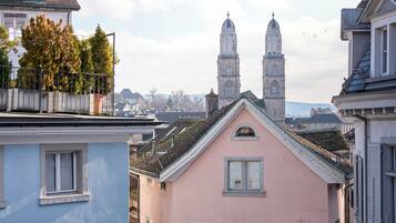 Un bâtiment rose orné d’une fresque murale, une église à deux tours et un ciel dégagé.