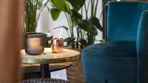 Une pièce avec une table ronde, une chaise bleue et une plante en pot.