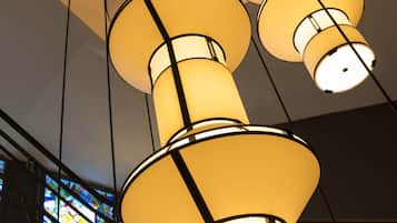 A series of cylindrical light fixtures suspended from the ceiling in a building.