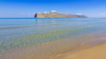 Na praia, espreguiçadeiras, guarda-sóis, toalhas de praia
