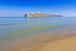 En la playa, sillas reclinables de playa, sombrillas, toallas de playa