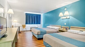 Hotelkamer met twee bedden, een bureau, een stoel, een raam met gordijnen en wandlampen.