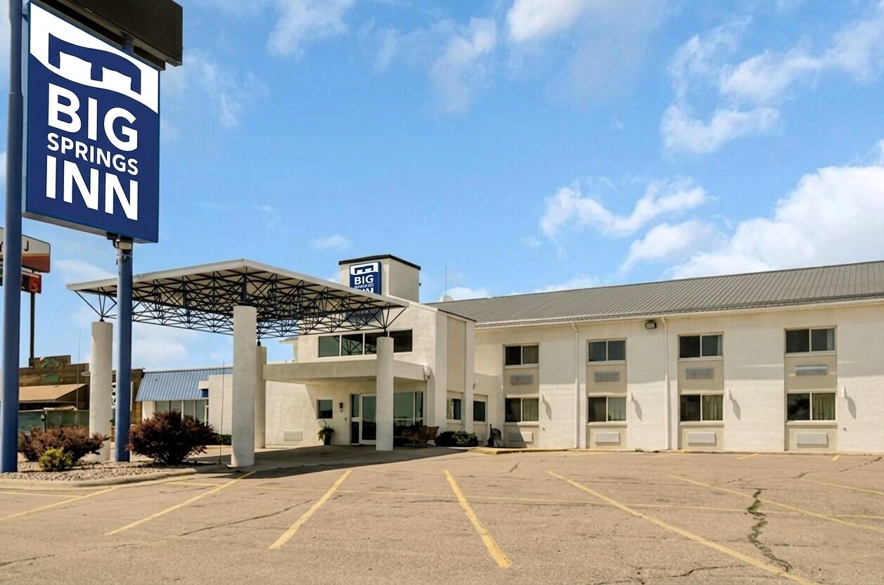 Hotel Big Springs amb un ampli pàrquing, entrada coberta i façana senzilla.