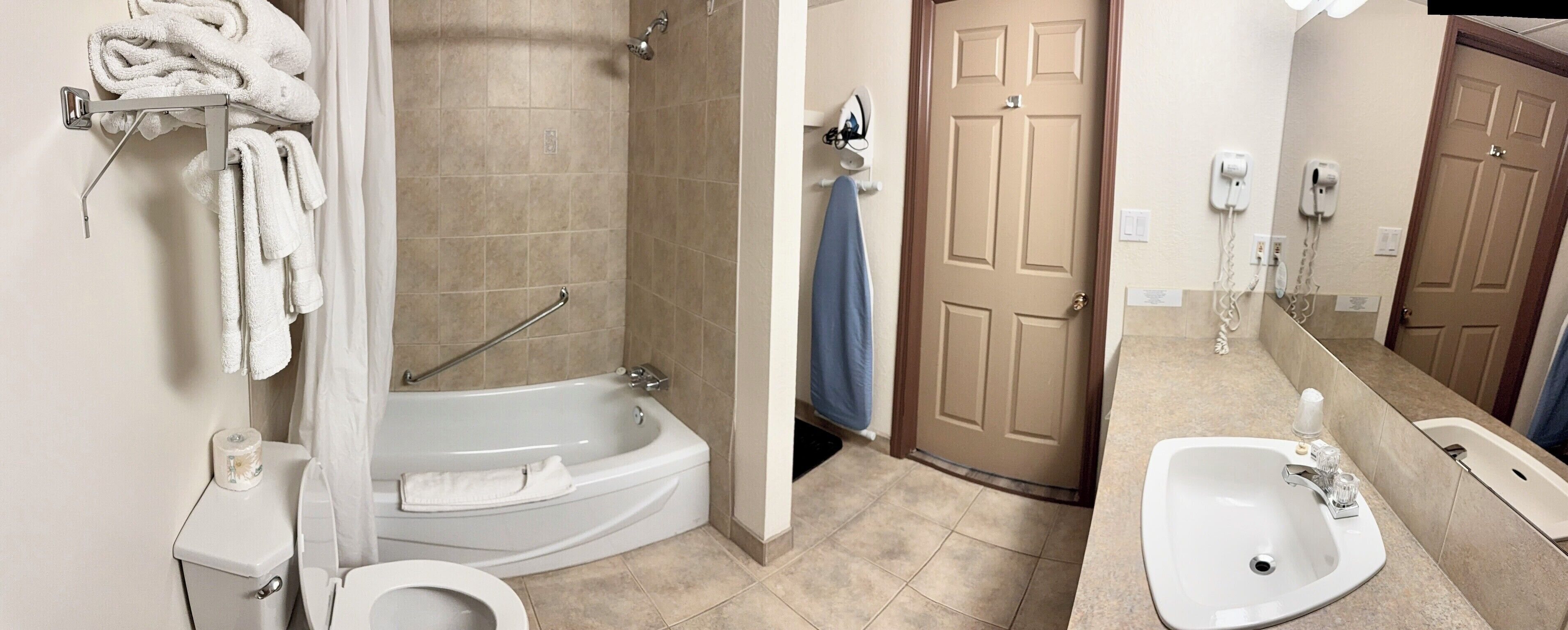 A bathroom with a toilet, a bathtub, and a sink.