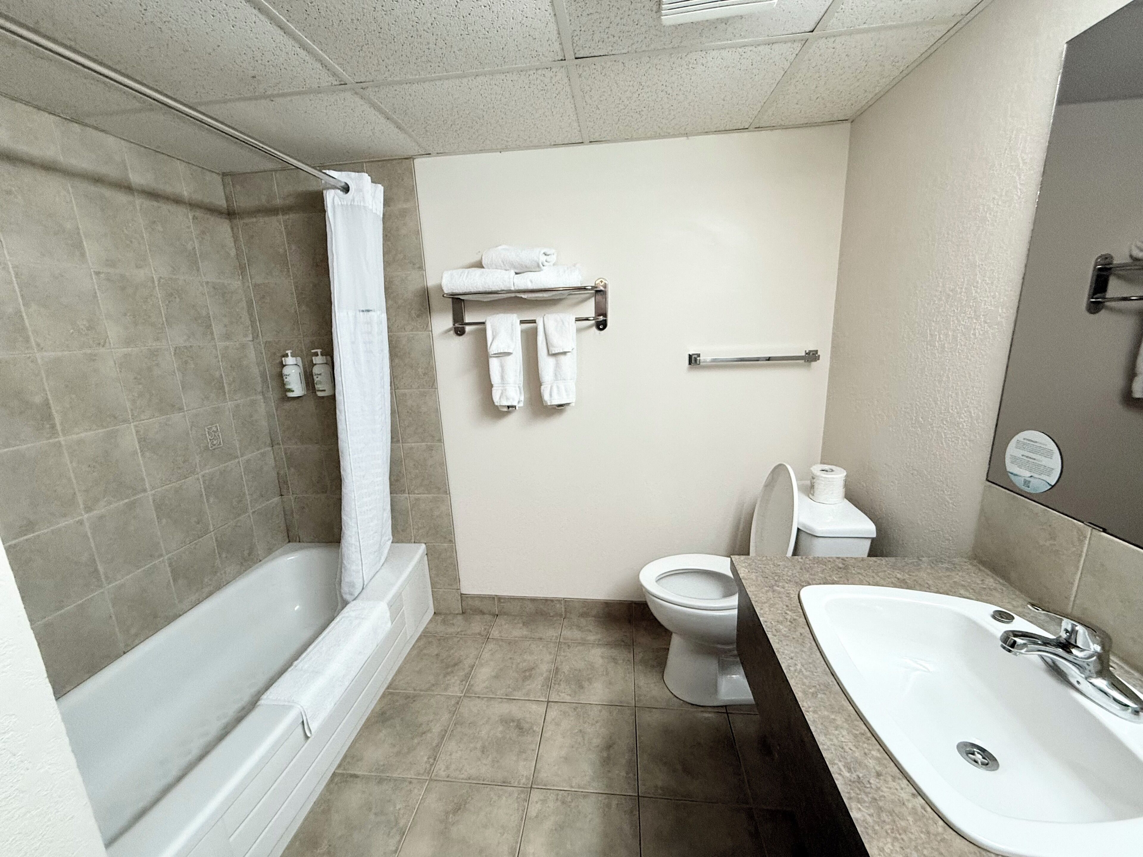 A bathroom with a bathtub, toilet, and sink.