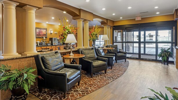 A lobby with leather chairs, a reception desk, and a large window with a view. - Best Western Plus Red River Inn (Clarendon)