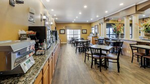 A hotel breakfast area with a coffee machine, seating, and a sign indicating no pets allowed in the breakfast area. - Best Western Plus Red River Inn (Clarendon)