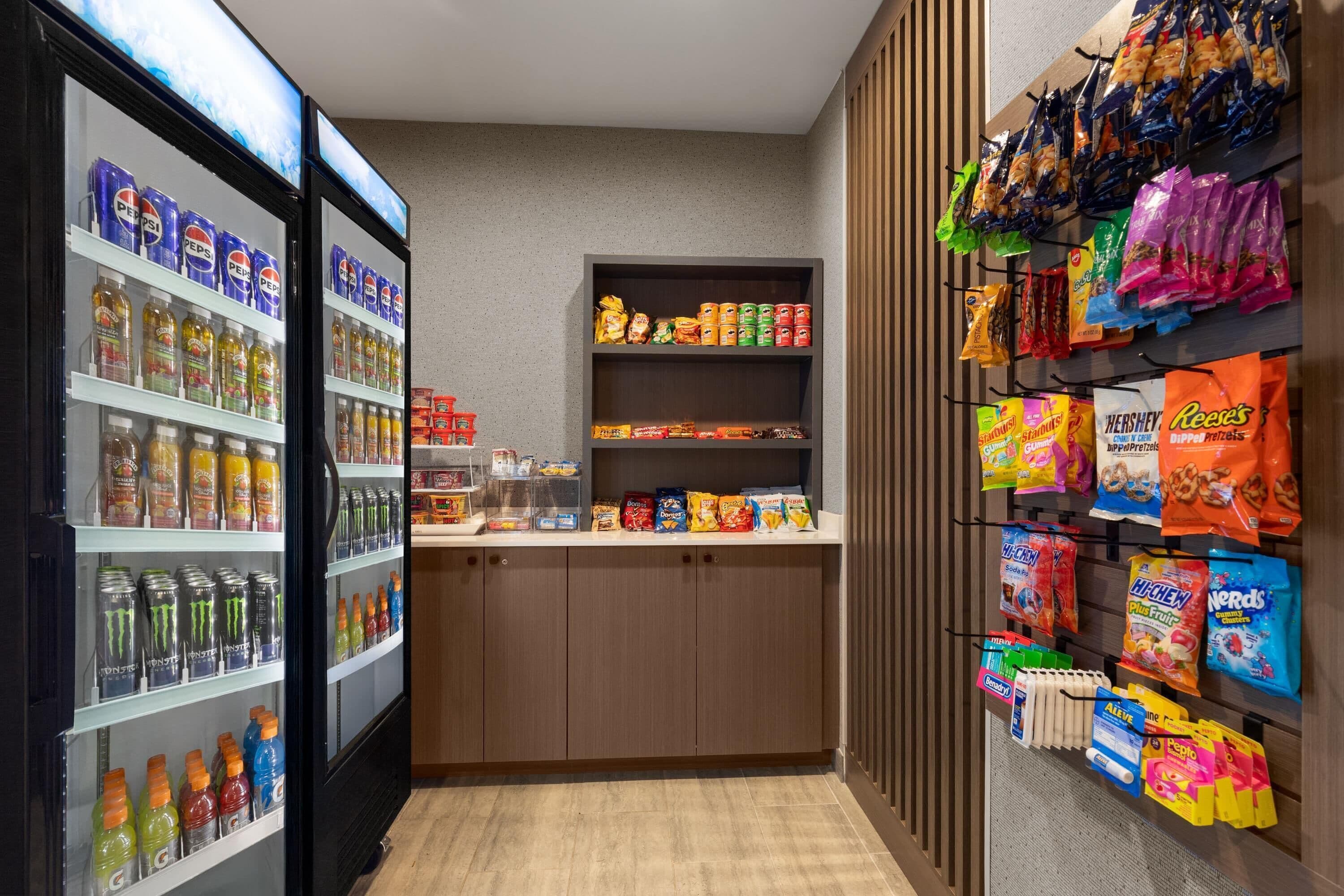Een assortiment snacks en drankjes, waaronder Pepsi, Monster en andere dranken, evenals chips en snoep.