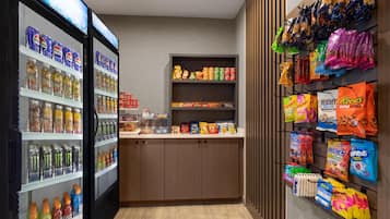 Een assortiment snacks en drankjes, waaronder Pepsi, Monster en andere dranken, evenals chips en snoep.