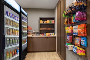 Eine Auswahl an Snacks und Getränken, darunter Pepsi, Monster und andere Erfrischungsgetränke sowie Chips und Süßigkeiten.