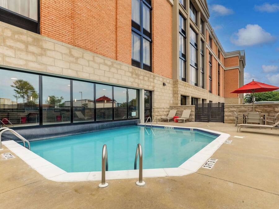 A swimming pool with a brick building in the background.