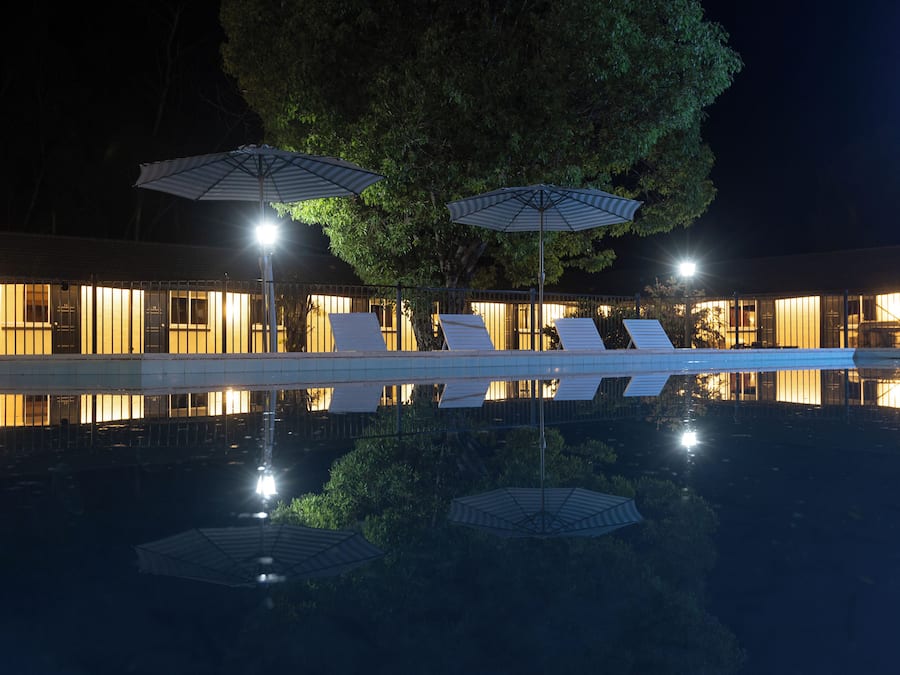 Una piscina al aire libre, sombrillas, tumbonas