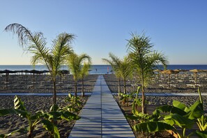 Pantai pribadi, kursi berjemur, payung pantai, dan handuk pantai