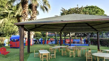 Enjoy dining or socializing in this outdoor pavilion surrounded by a grassy area and colorful play structures.