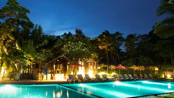 Una piscina al aire libre, sombrillas, tumbonas
