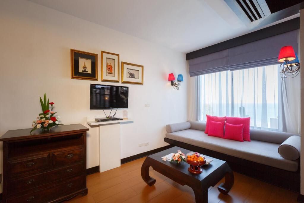 A living room with a sofa, a coffee table, a TV, and a dresser.