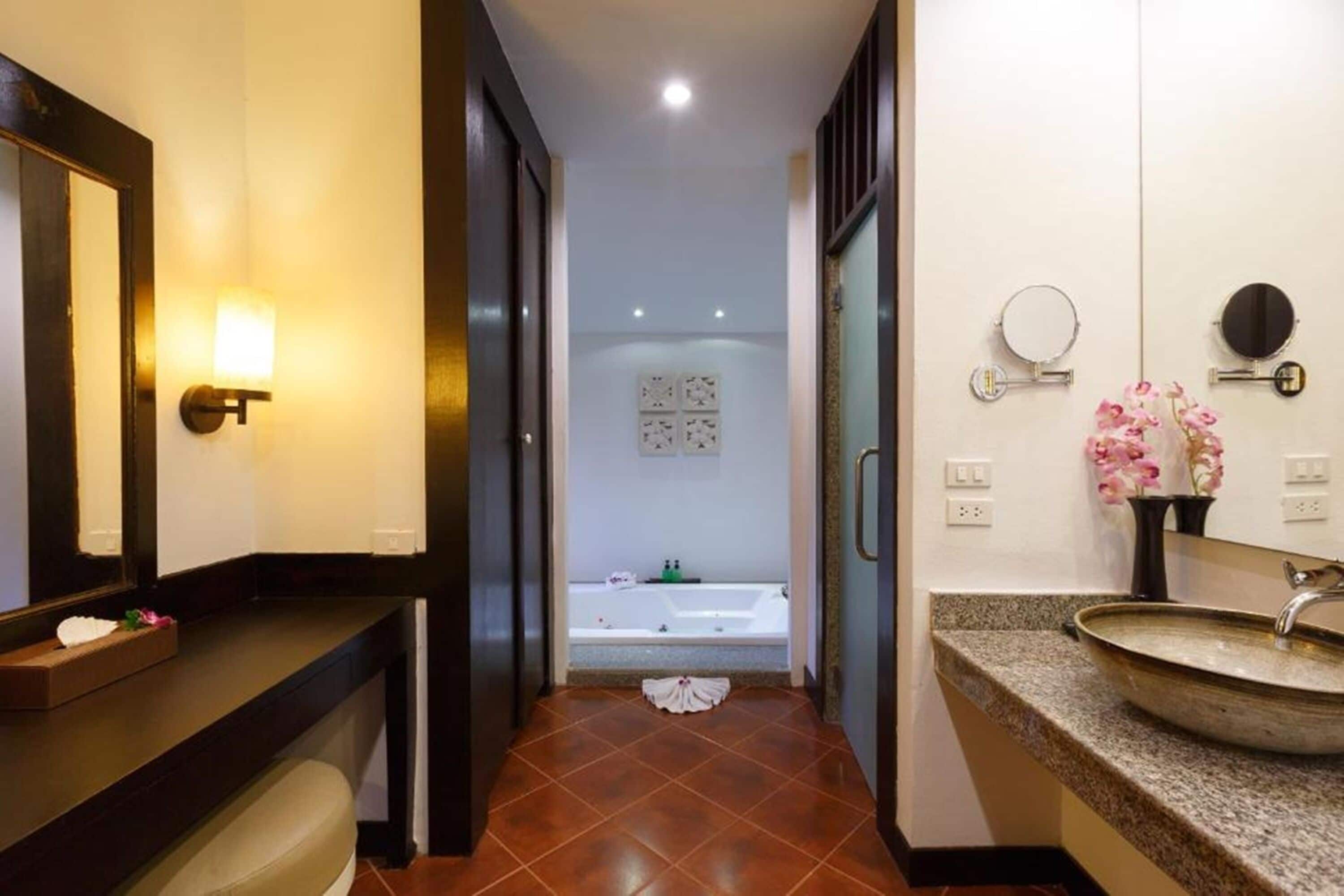 A modern bathroom with a large mirror, a vanity with a sink, and a bathtub.