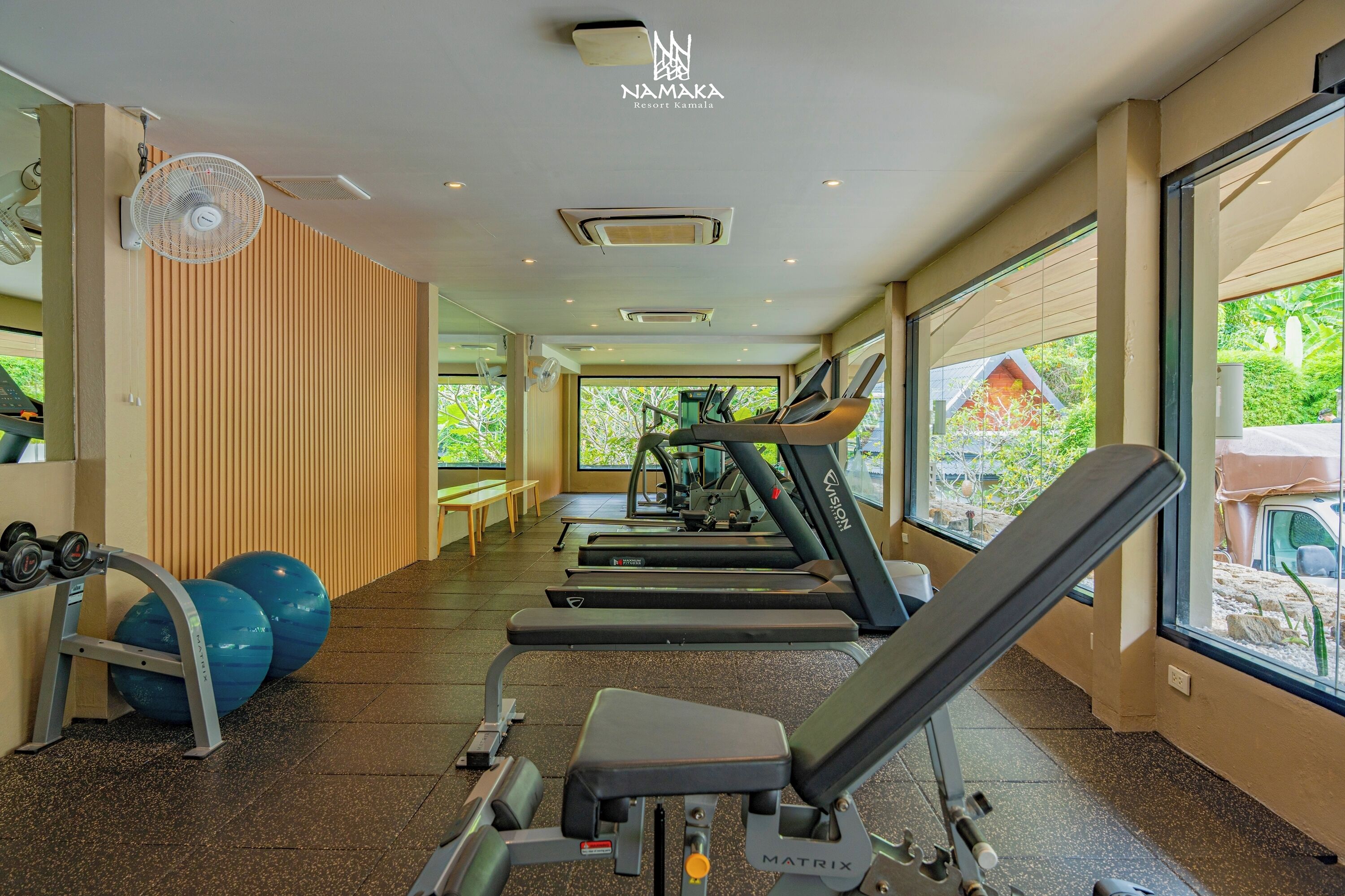 A gym with treadmills, weight machines, and exercise balls.