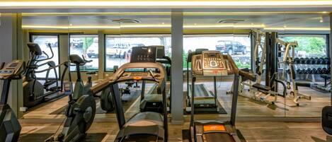 A gym with treadmills, elliptical machines, and weight equipment.
