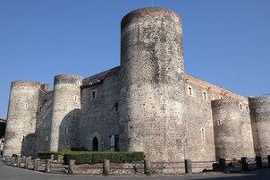 Un castello in pietra storico con diverse torri e un'imponente torre centrale.