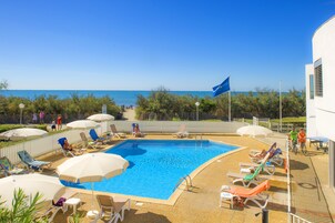 Piscine extérieure, parasols de plage, chaises longues