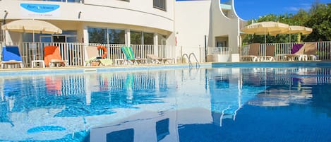 Piscine extérieure, parasols de plage, chaises longues