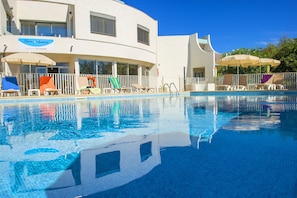 Piscine extérieure, parasols de plage, chaises longues