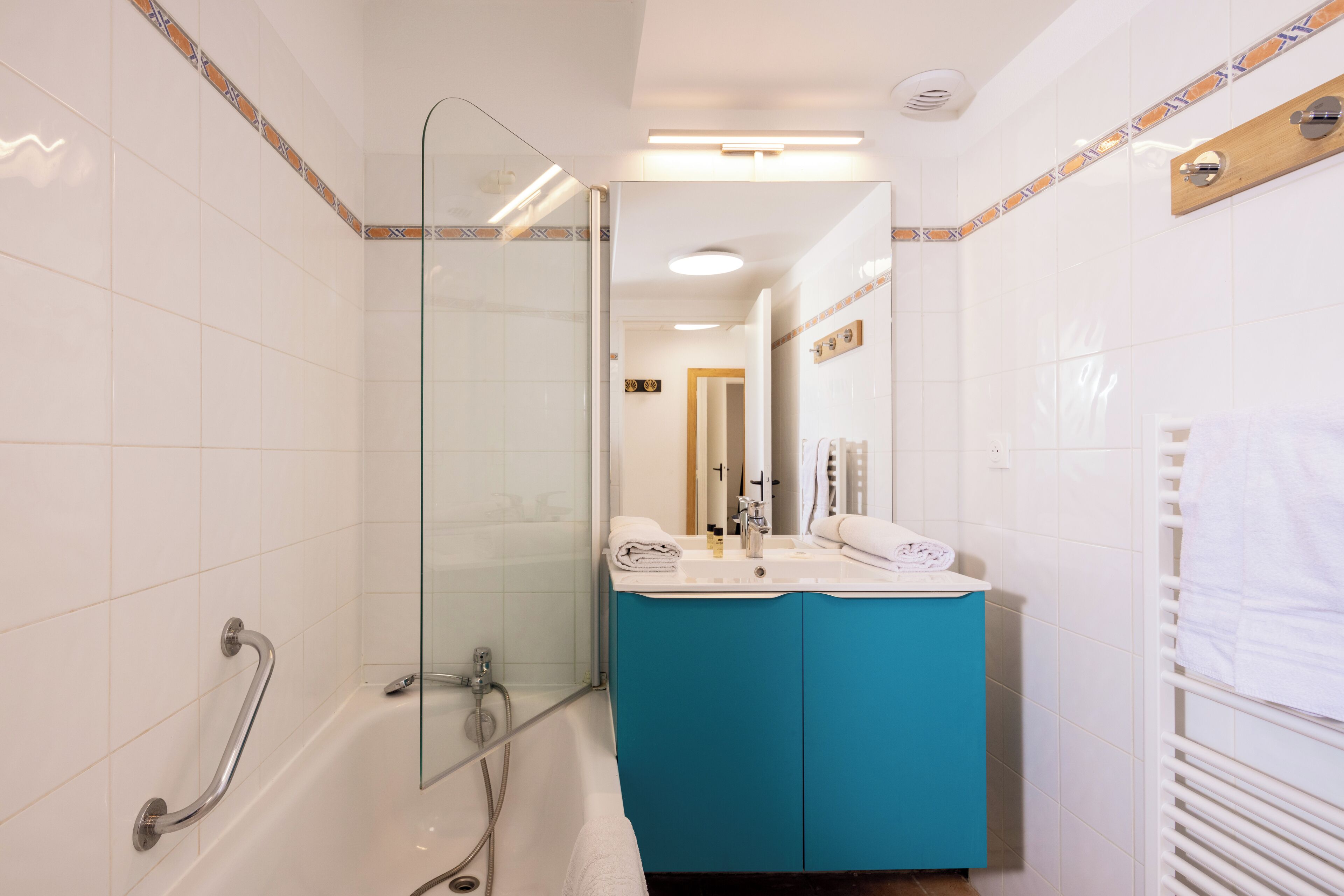 Une salle de bain avec une douche à parois de verre, une baignoire et un lavabo avec un miroir.